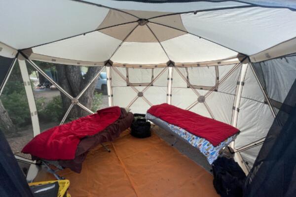 Two cots inside a gazebo pop-up tent