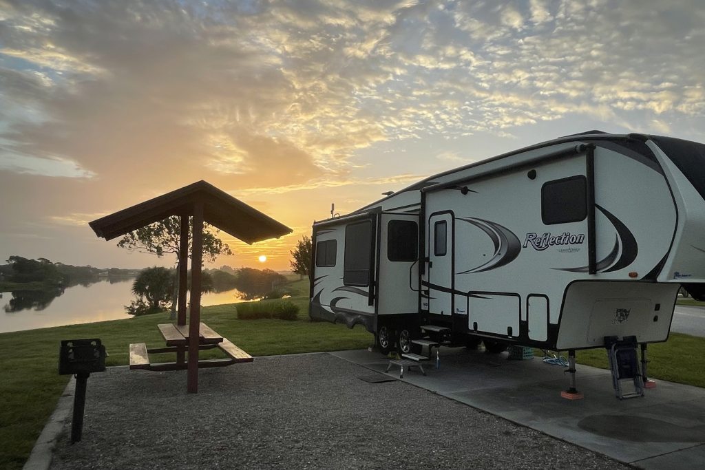 Picture of a fifth wheel parked at a lake-front campsite in Florida
